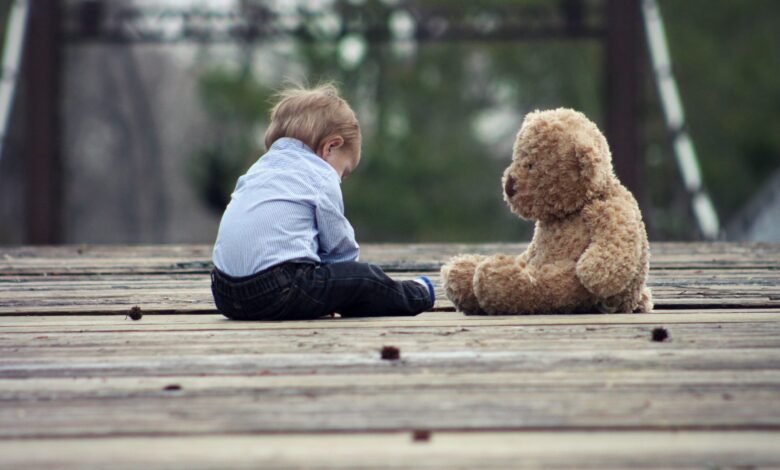 A child sits with a teddy bear. They look like they're deep in conversation.