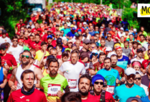 Marathon runners in bright colours run towards the camera in a sea of people